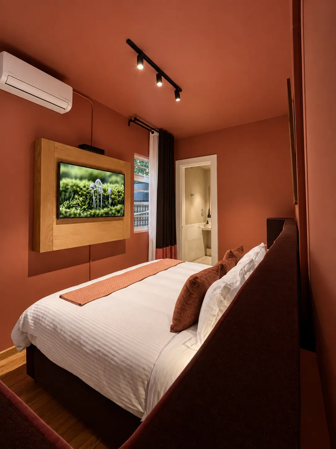 Dormitorio terracota diseñado por Housense con iluminación cálida y mobiliario integrado